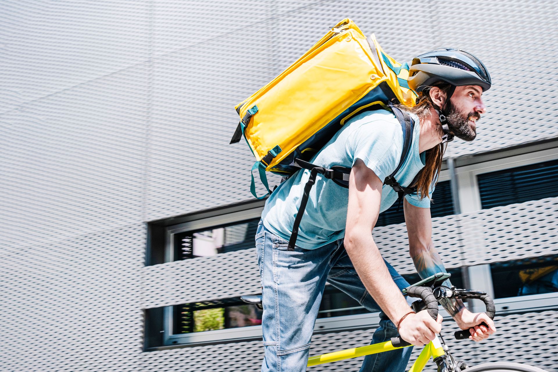 Les appareils durcis PaceBlade accompagnent les coursiers alimentaires en mobilité Coursier urbain à vélo avec un sac à dos jaune