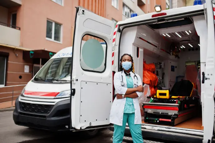 Female medical responder standing in front of an emergency ambulance